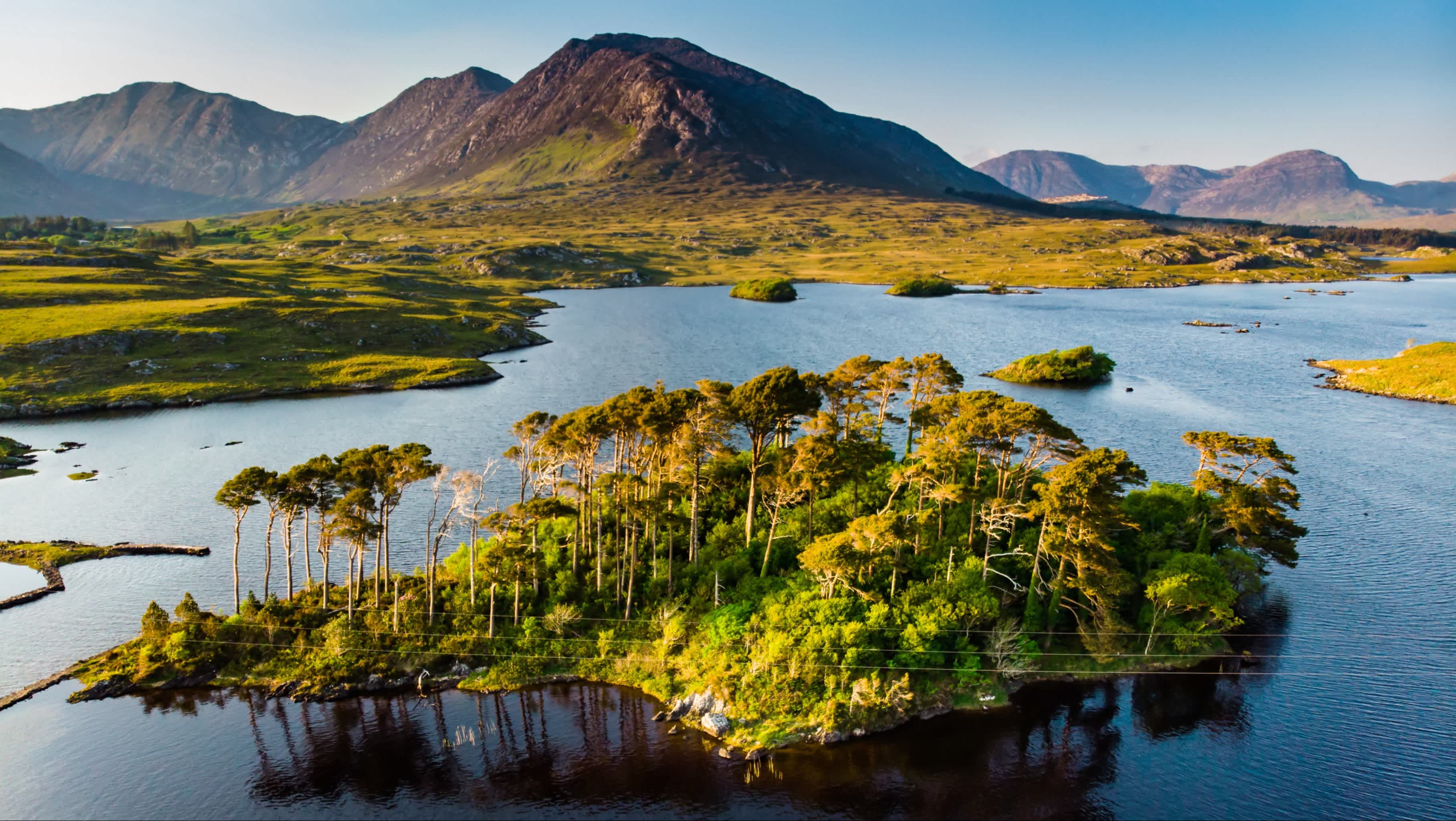 Pines Island en automne au coucher du soleil, Derryclare Lough, Connemara, comté de Galway, Irlande. Chaîne de montagnes Twelve Bens en arrière-plan.