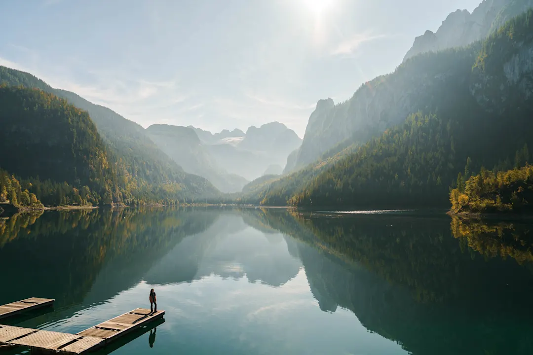 Woman on pier near the lake and looking at view of Gosausee and mountains