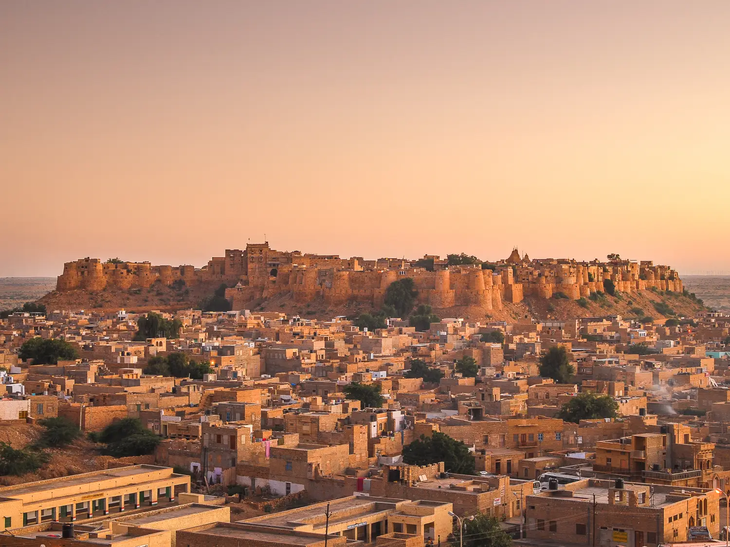 Indien, Jaisamler, Festung Jaisalmer Fort bei Sonnenuntergang, goldene Festung thront über der Wüstenstadt mit sandfarbenen Gebäuden in Rajasthan.