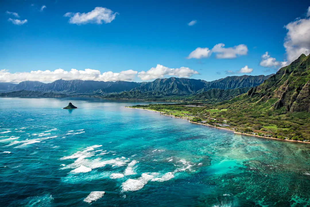 Boot vor steilen Klippen und türkisfarbenem Wasser, Kauai, Hawaii, USA.