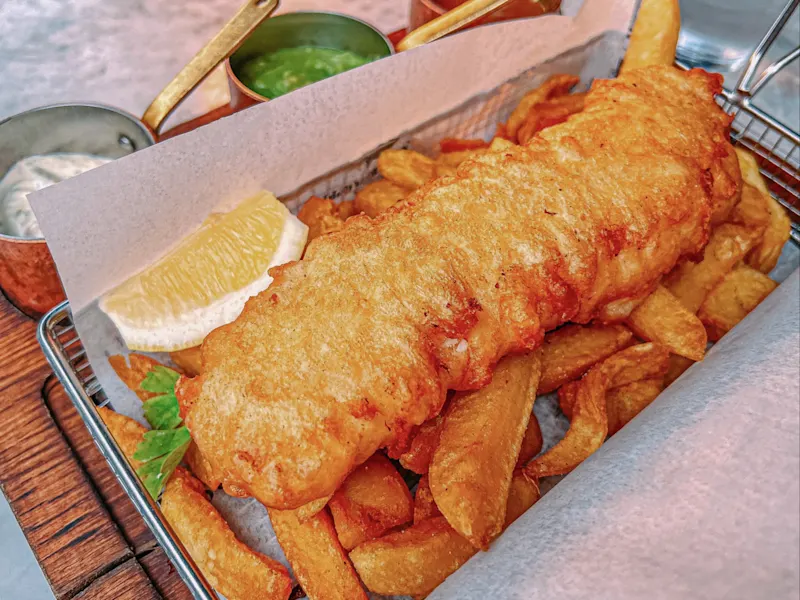 Fish and Chips: Frittierter Fisch mit Pommes, oft mit Erbsenpüree und Sauce