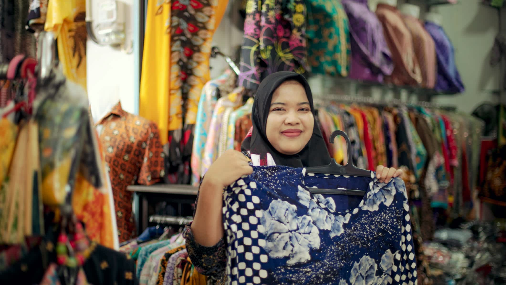 Une femme montre du tissu dans un centre commercial, Indonésie