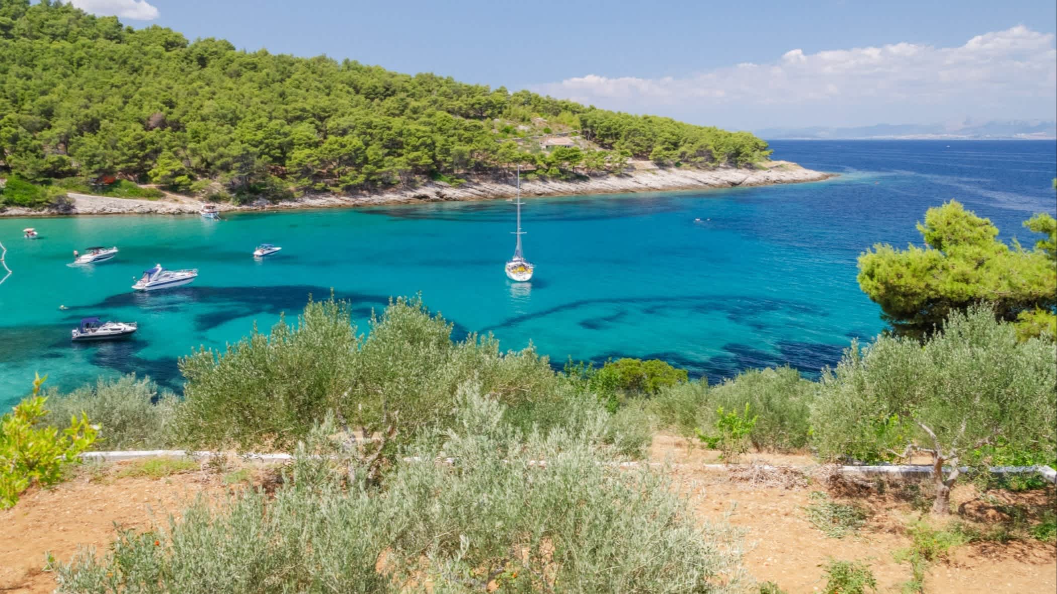 Die Bucht Lovrečina, Insel Brač, Kroatien mit Blick auf das blaue Wasser, Segelboote und die Hügel der Bucht.