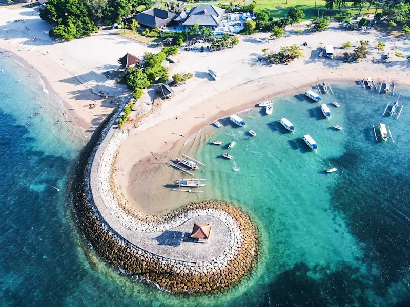 Indonesien, Bali, Sanur Sandstrand mit kleinen Booten und traditionellem Pavillon. Sanur, Bali, Indonesien.