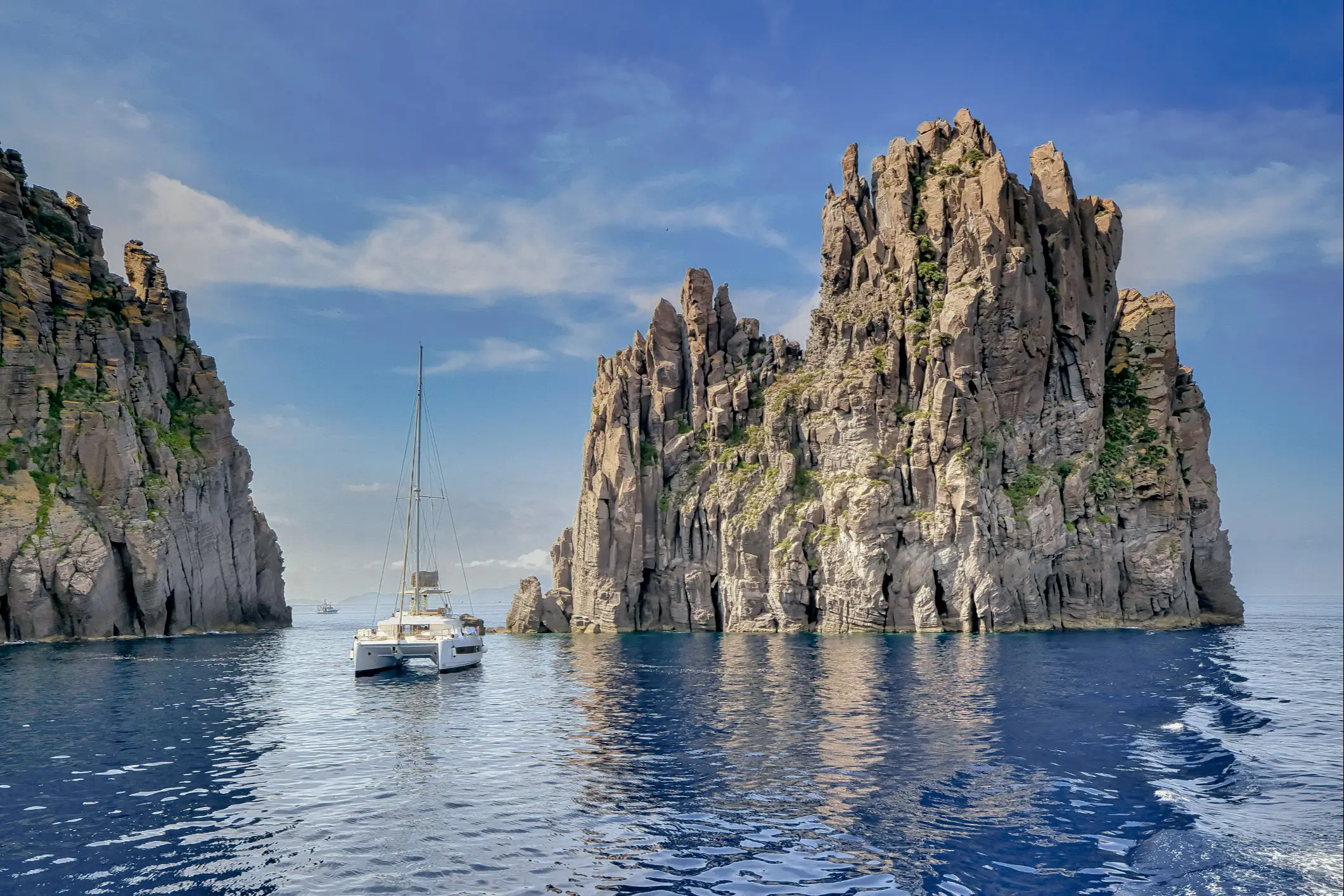 Sailing boat on the rock Scoglio Spinazzol, Panarea, Sicily, Italy