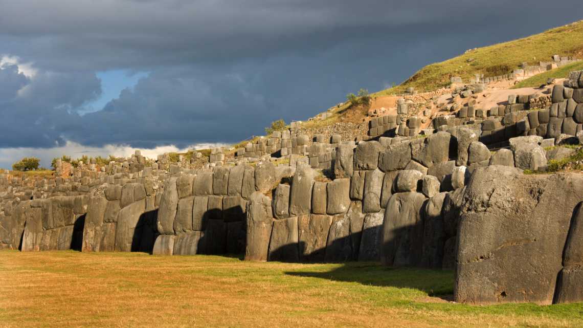 Vue horizontale du Sacsayhuam, murs de pierre, au crépuscule d'une journée orageuse, près de Cuzco, Pérou
