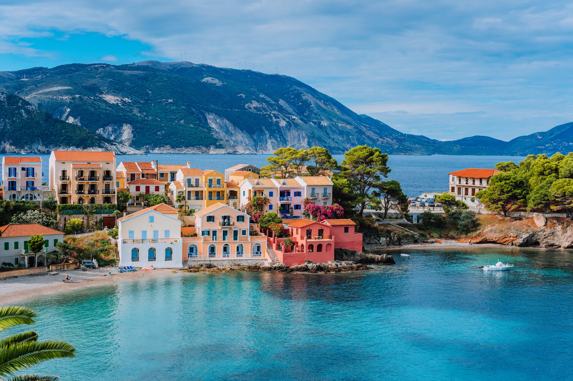 Schöner Panoramablick auf das Dorf Assos mit lebhaften bunten Häusern in der Nähe von blautürkisfarbenen und transparenten Lagunen der Bucht. Kefalonia, Griechenland.

