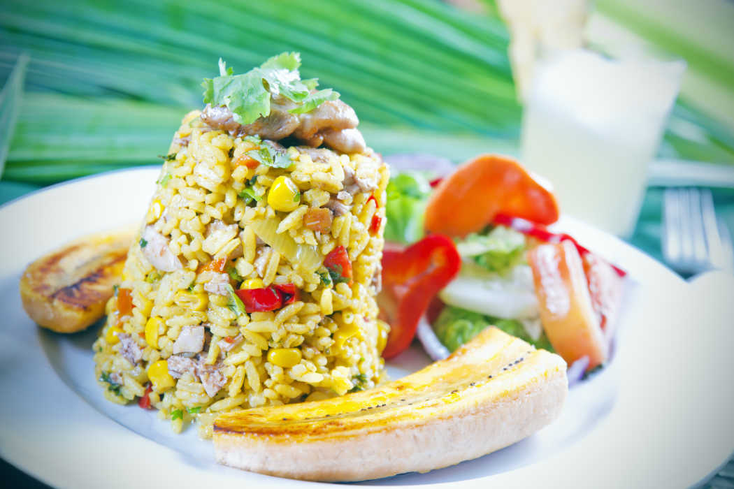 Arroz con pollo - traditionelles costa-ricanisches Gericht aus Reis und Hähnchen mit Salat und Kochbananen.
