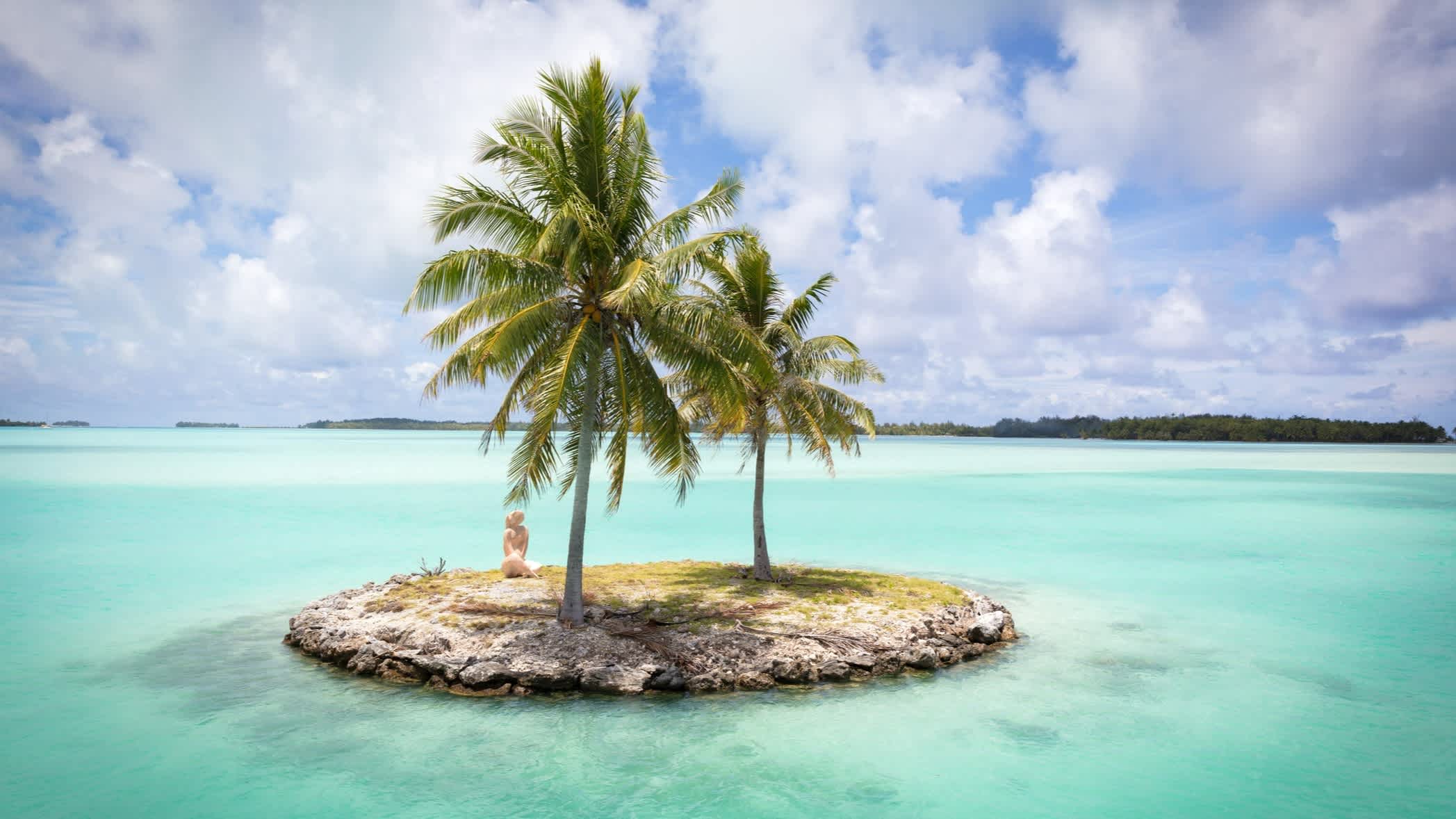 Lagune und kleine Insel mit Palmen auf Bora Bora.