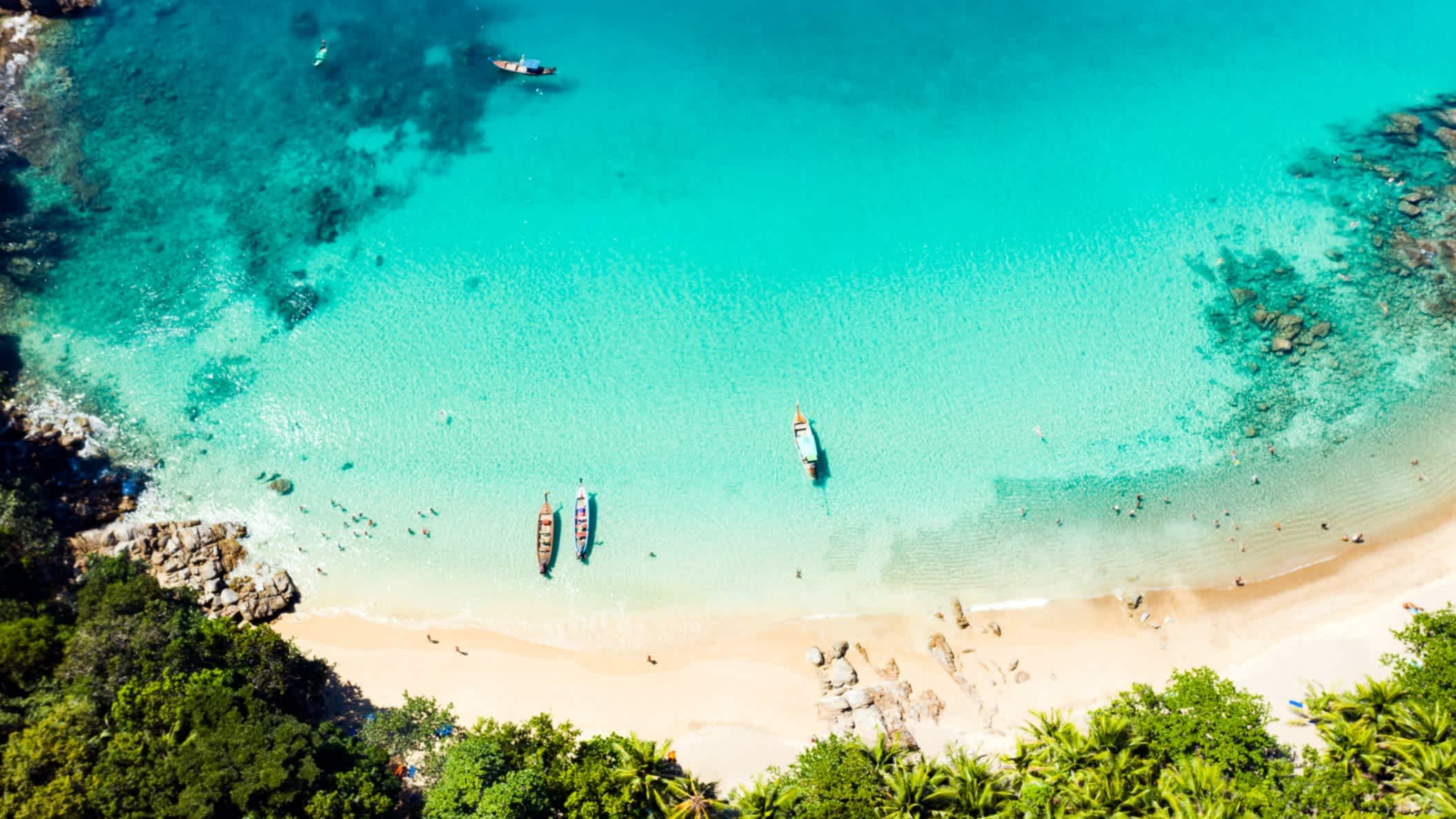 Vue aérienne de Banana Beach, avec des bateaux et une mer turquoise, à Phuket en Thaïlande.