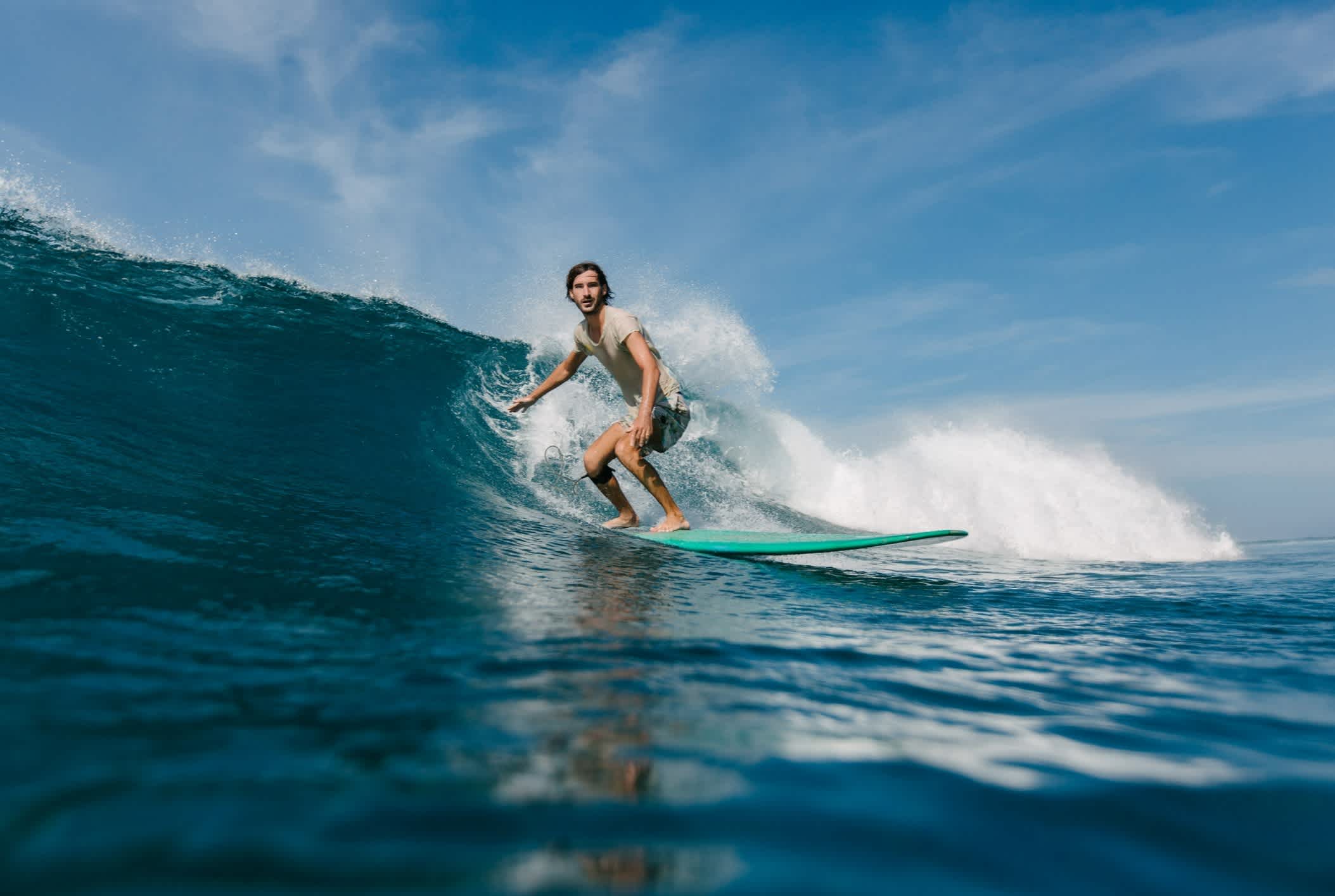  Junger Mann auf Surfbrett an sonnigen Tag