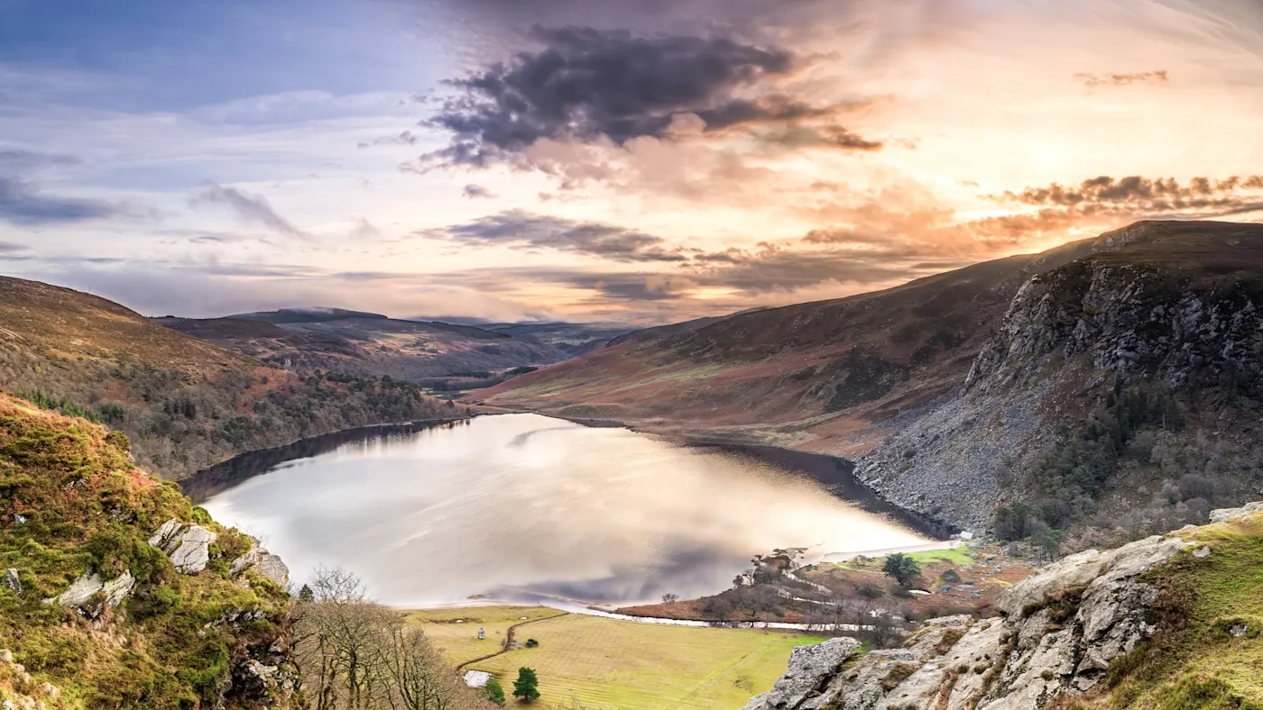 Irland, Wicklow, See See von Hügeln umgeben, reflektiert die Farben eines dramatischen Himmels. Wicklow, Irland.