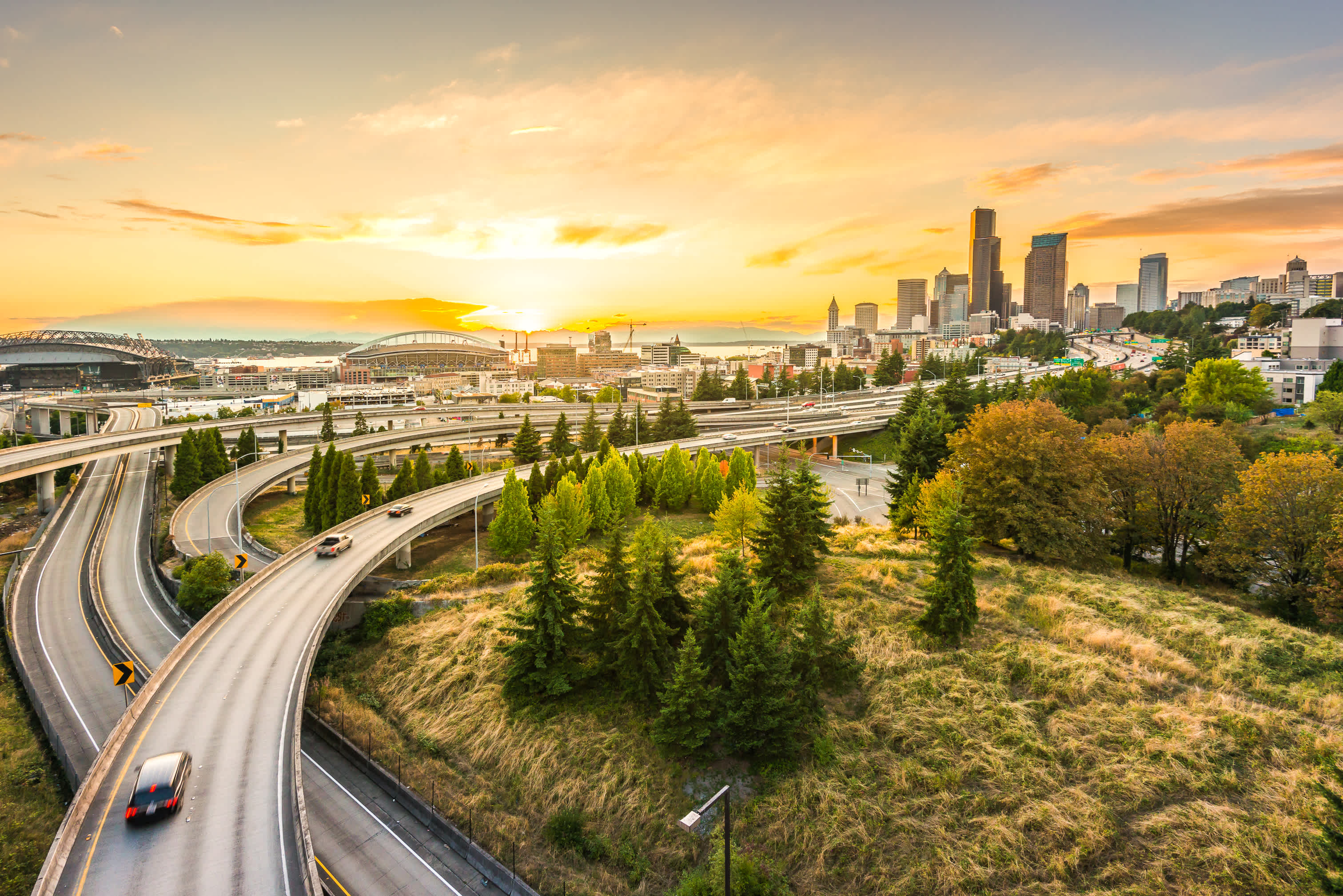 Die Skylines von Seattle und die Autobahnen der Interstate vereinigen mit der Elliott Bay und dem Hintergrund am Wasser von Seattle, Washington State, USA.