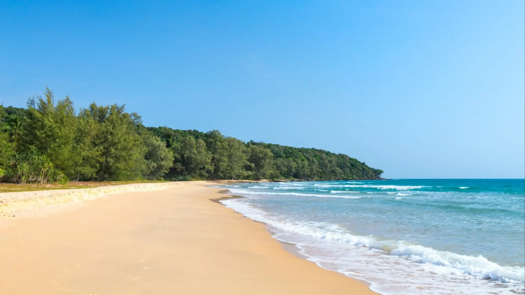Lonely Beach, Cambodia Gelber, langer Sandstrand am Meer des Lonely Beach, Cambodia mit natürlicher Vegetation am Rand sowie Sonnenschein.