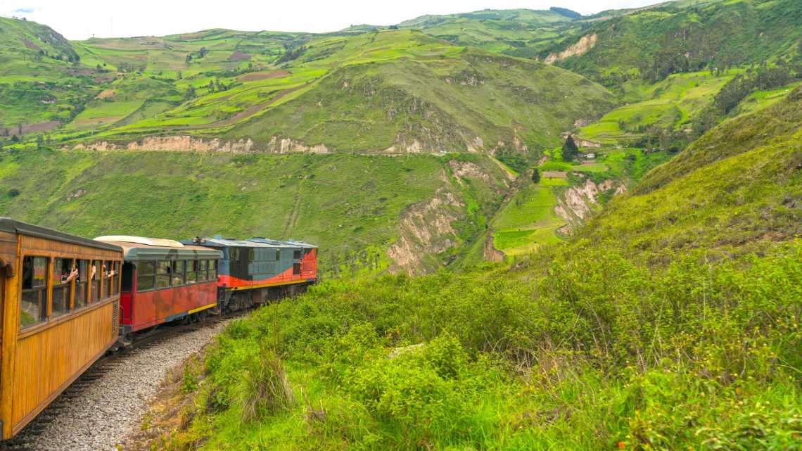 Fahrt mit dem alten Zug Nariz del Diablo in grüner Landschaft in Ecuador.
