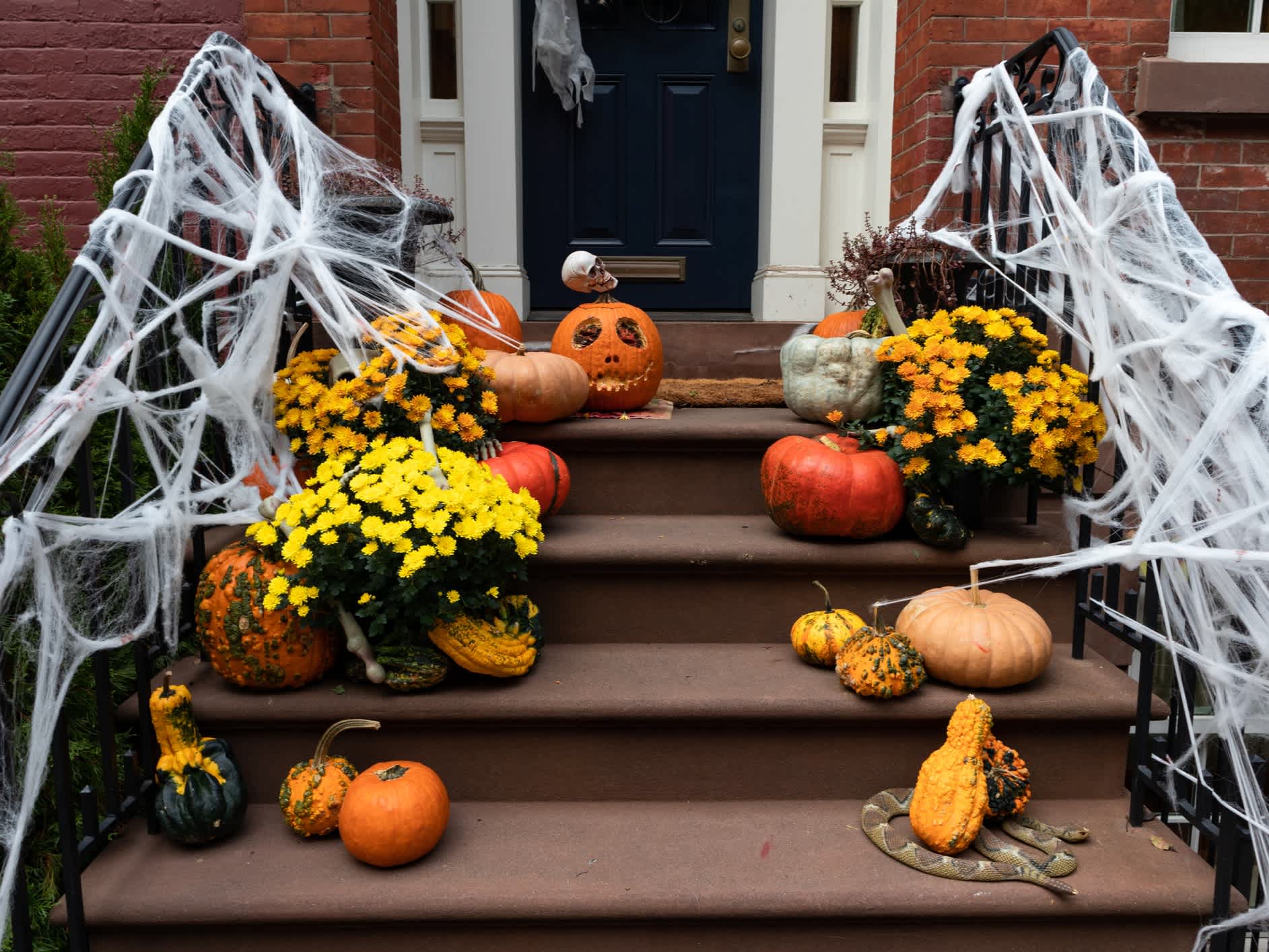 Halloween-Dekorationen auf der Treppe eines alten Brownstone-Hauses in New York , USA. 