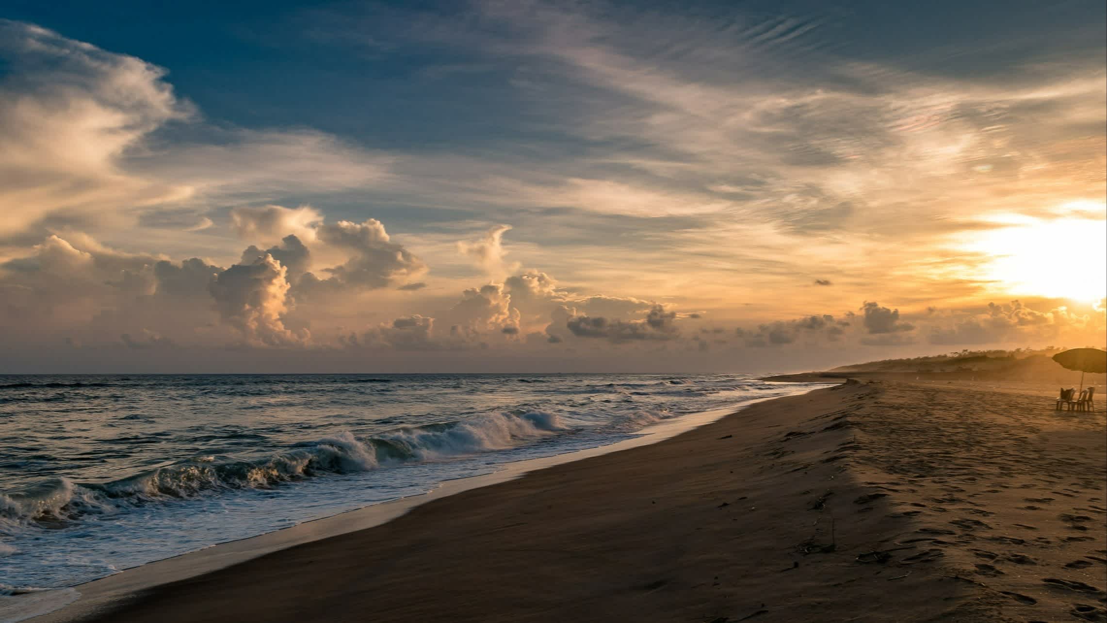 Sonnenaufgang am Puri Beach, Odisha, Indien bei welligem Meer.