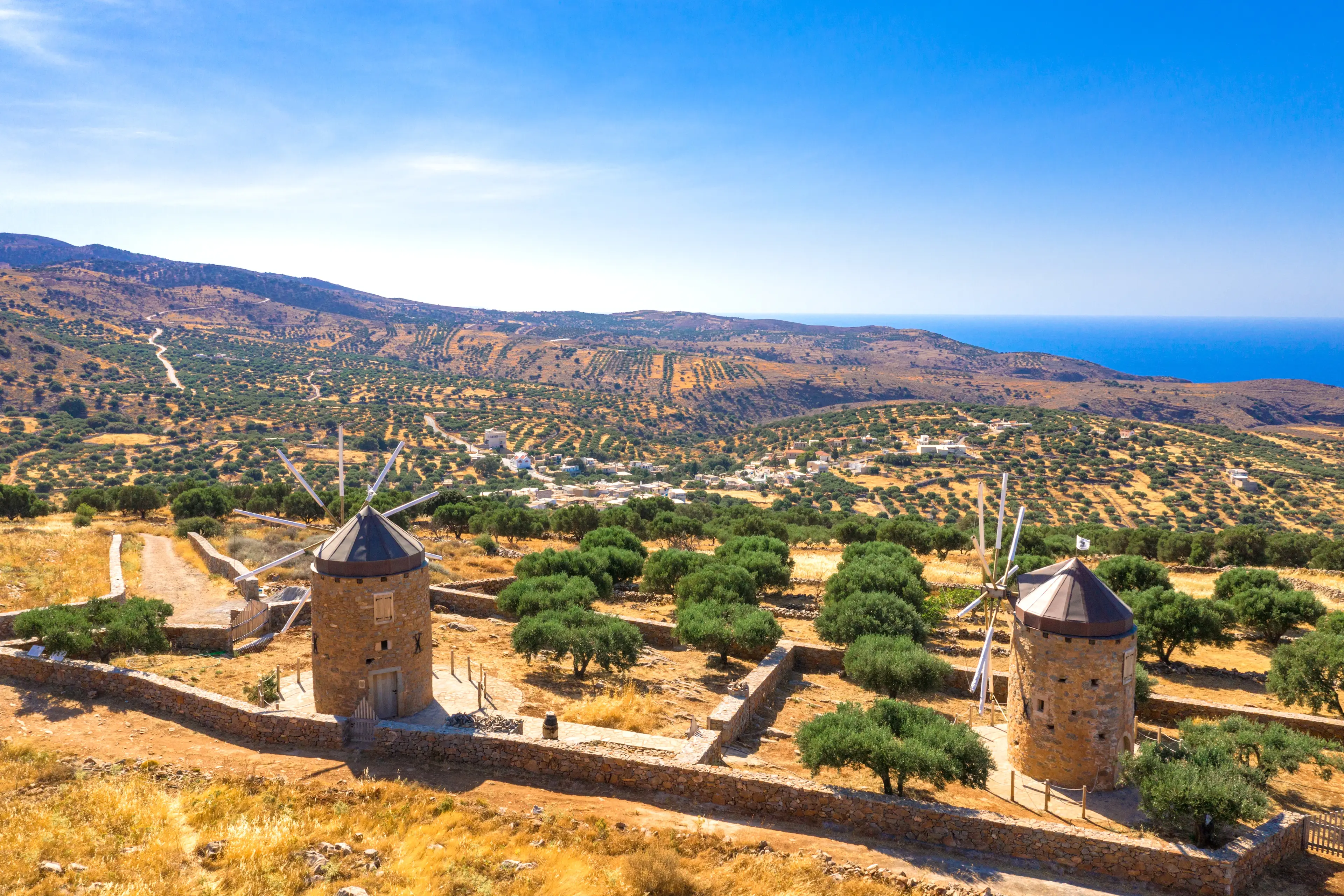 Grèce, Crète, Lassithi Anciens moulins à vent sur un plateau fertile avec la mer en arrière-plan