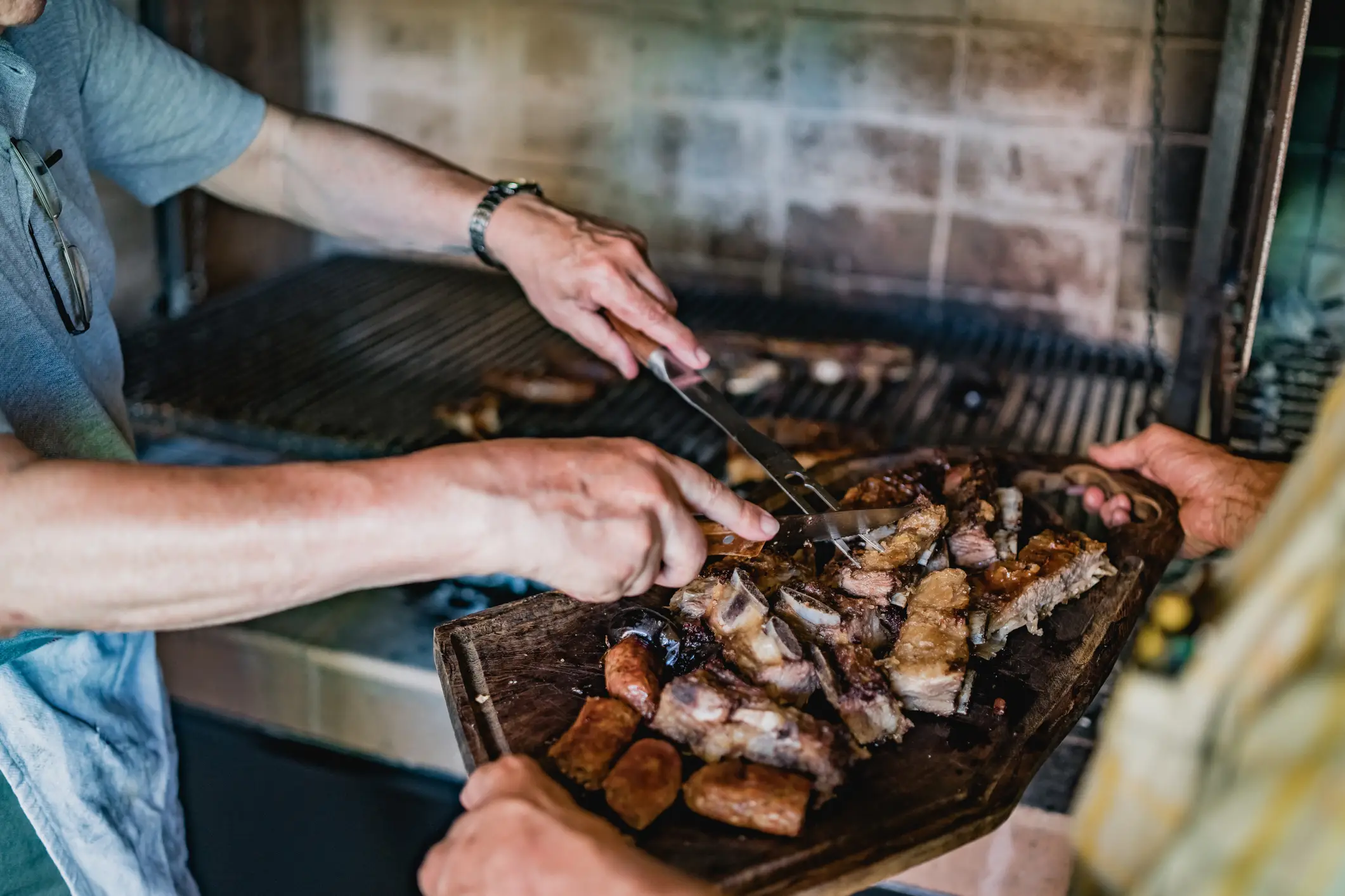 Argentinien, Asado-Fleisch Zwei Männer servieren Asado-Fleisch, Argentinien