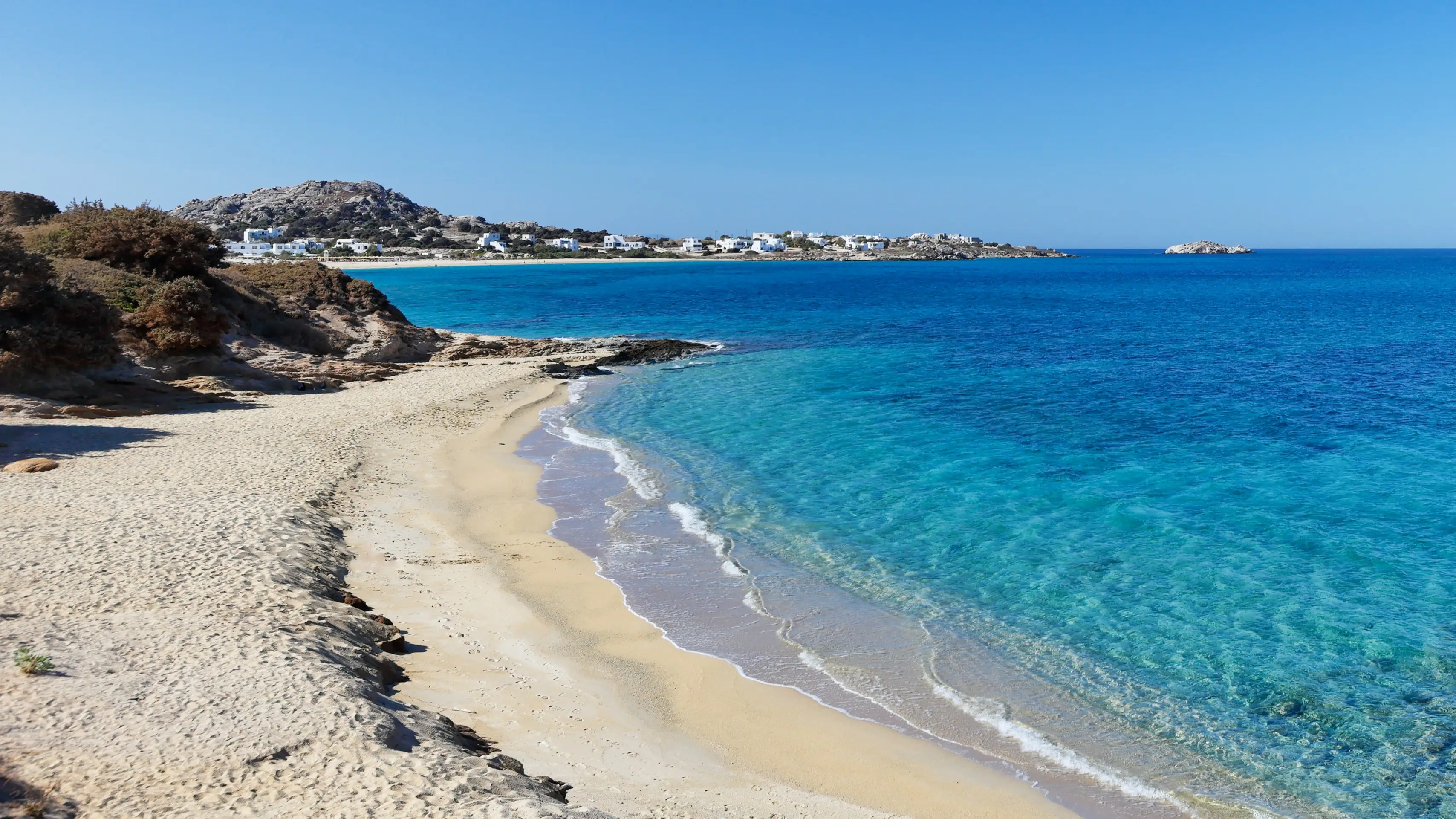 Griechenland, Naxos, Paralia Orkos Blick auf den Strand Paralia Orkos auf Naxos, Griechenland, mit Felsen, beigem Sand und azurblauem Meer.