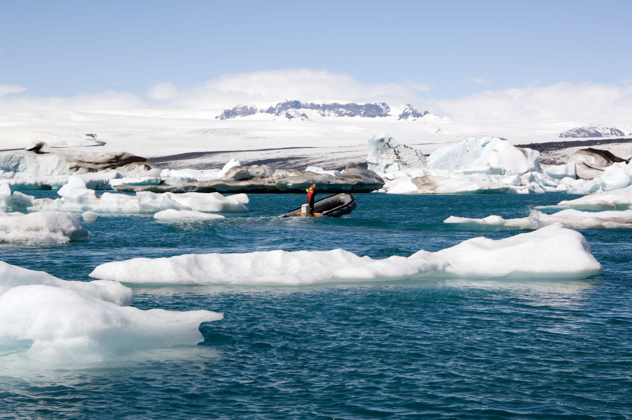 Un bateau entre les icebergs sur la lagune du glacier, Islande.