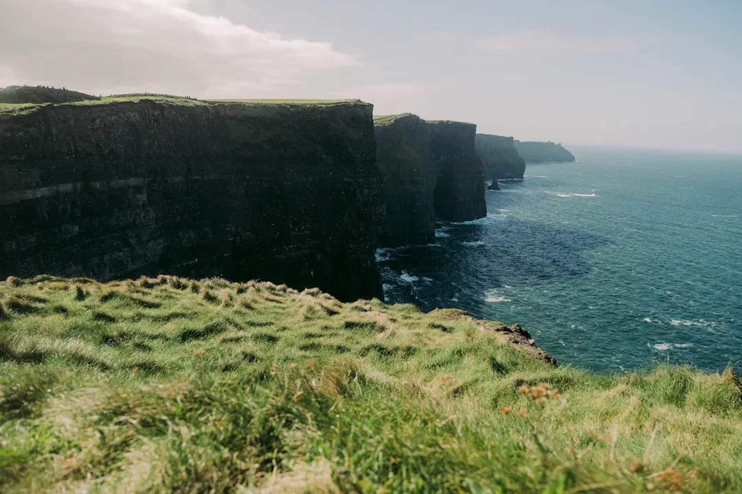 Blick auf die Cliffs of Moher mit einem etwas dunklen Himmel, Irland