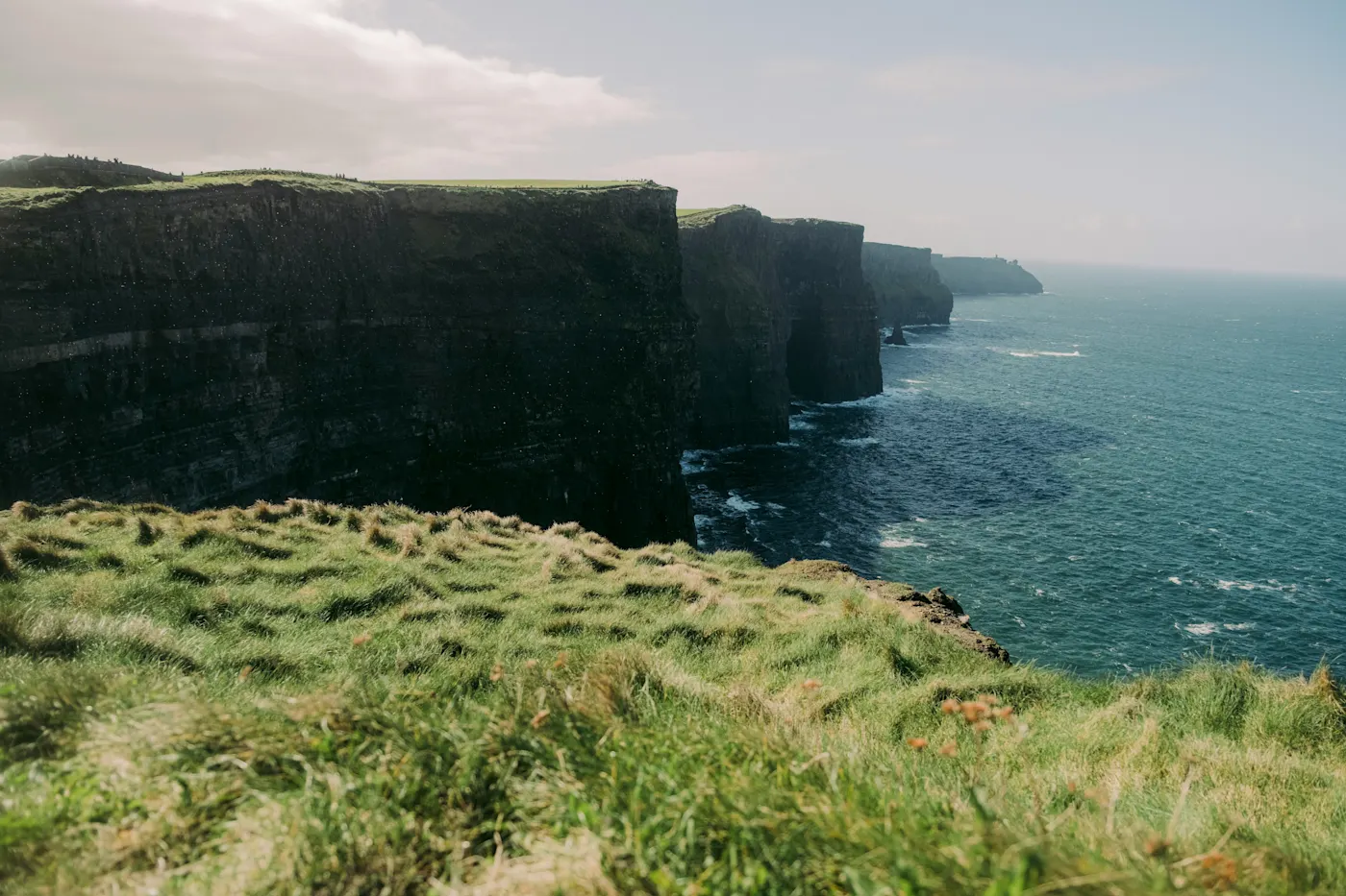 Blick auf die Cliffs of Moher mit einem etwas dunklen Himmel, Irland