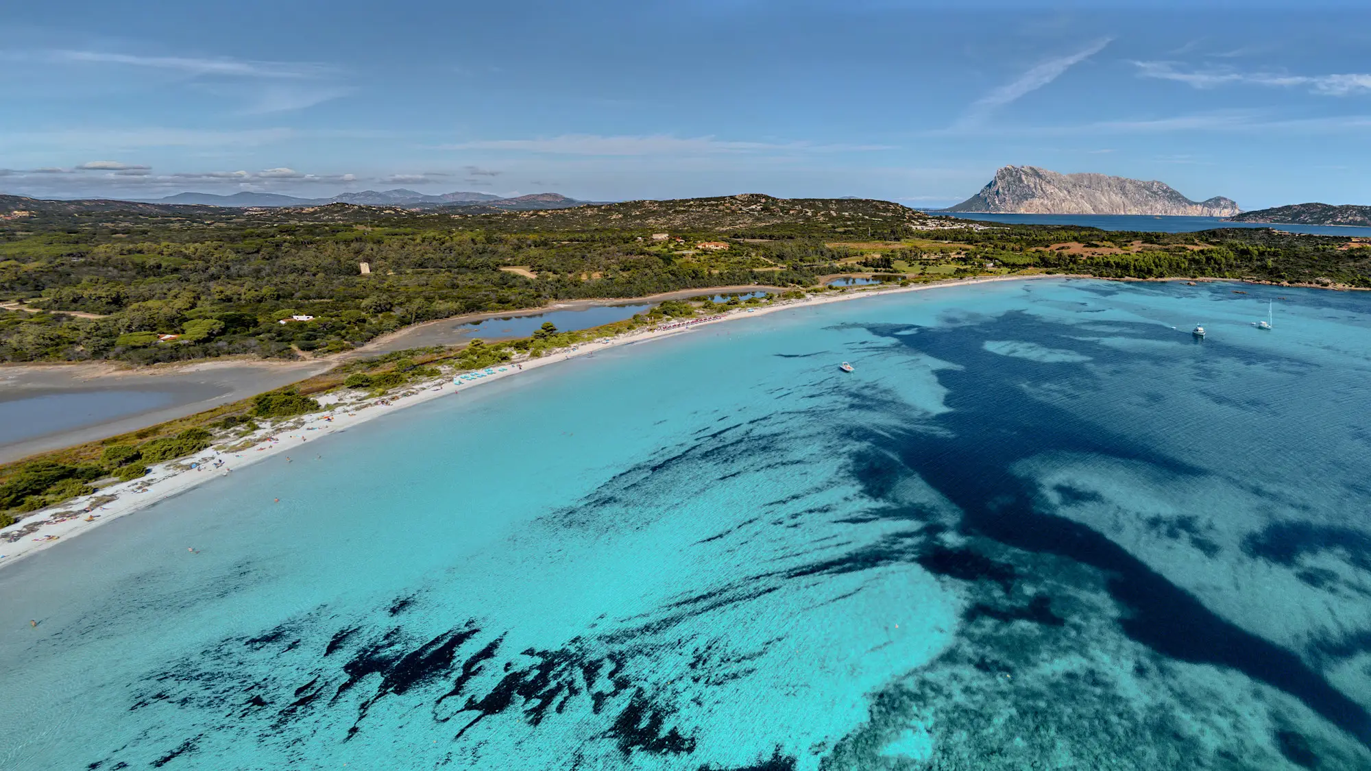 Luftaufnahme von Cala Brandinchi in Sardinien, Italien mit Überblick der Küstenlinie sowie entfernten Inseln.

