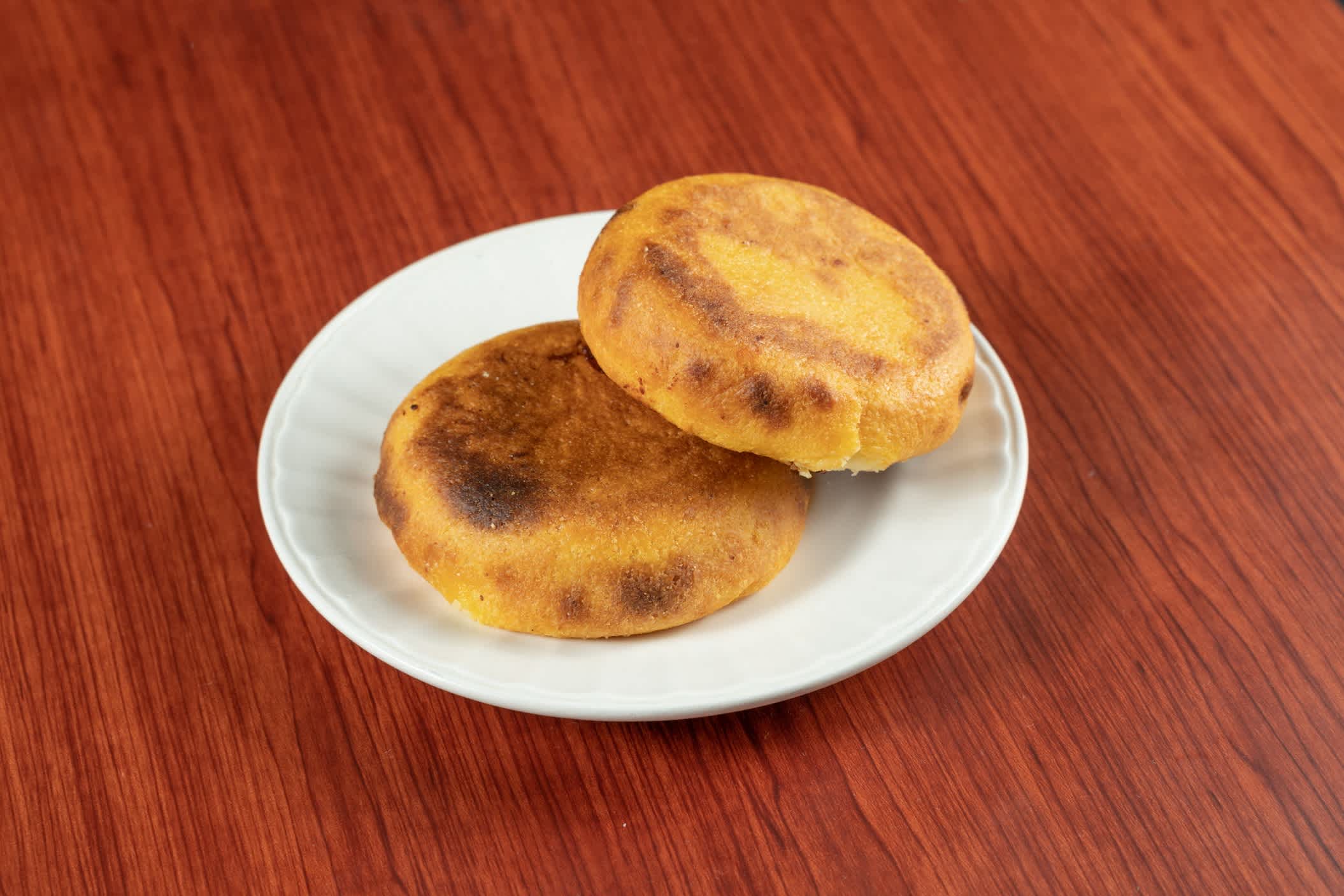 Eine frische heiße Arepa beliebt in Kolumbien und Venezuela gemacht von zwei Maiswaffeln, die gebraten werden, bis Käse dazwischen schmilzt, Essen