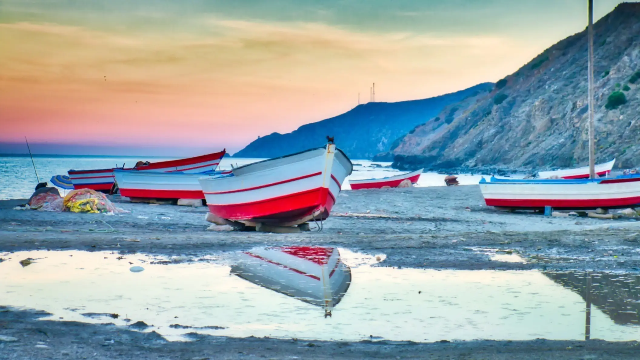 Marokko, Oued Laou-Strand Fischerboote spiegeln sich im Wasser bei Ebbe und Dämmerung am Strand von Oued Laou, Chefchaouen, Marokko.