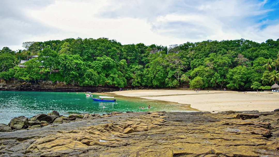 Sandstrand mit Booten und grünem Wasser. Isla Contadora, Perleninseln, Panama