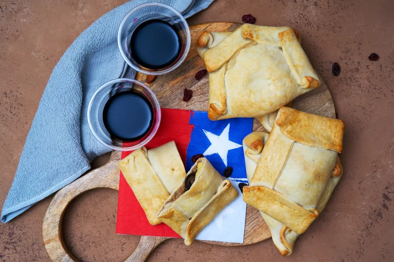 Chile, Empanadas de Pino Empanadas de Pino oder chilenische Rindfleisch-Empanadas mit Weinhintergrund
