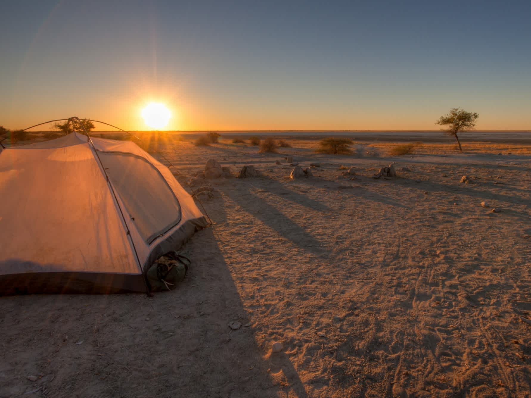 Panneau de sel au Botswana avec une tente au coucher du soleil.