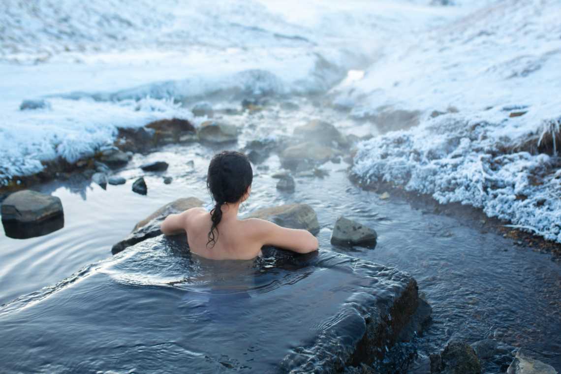 Das Mädchen badet im Winter in einer heißen Quelle in Island.