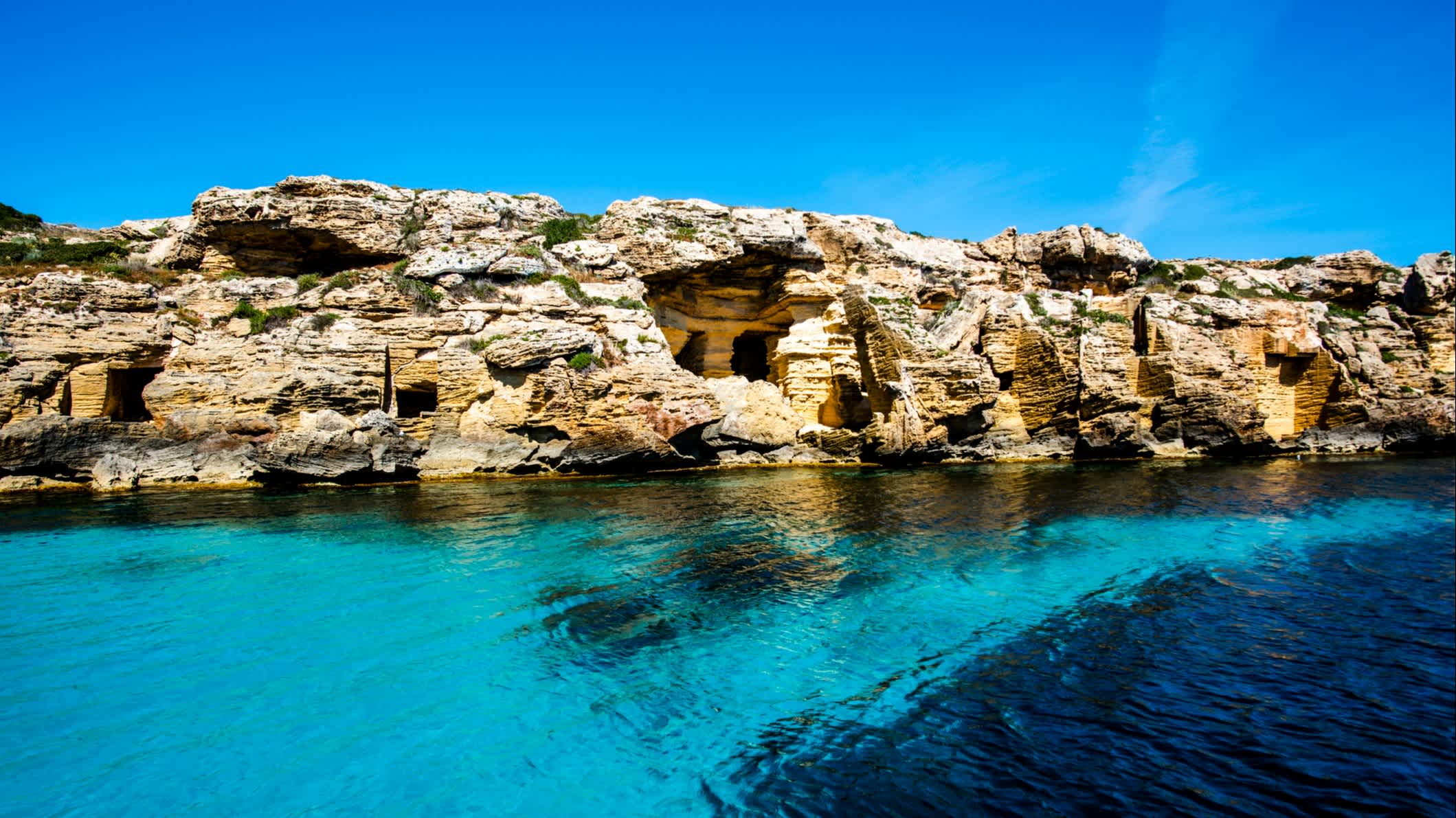 alte verlassene Tuffsteinbrüche an der Küste mit kristallklarem blauem Meer auf der Insel Favignana