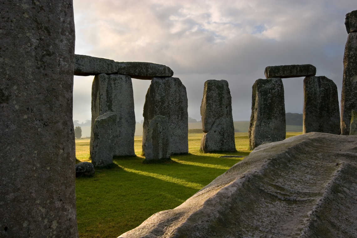 Le soleil se lève et projette ses rayons à travers les pierres massives sculptées à la main de Stonehenge, érigé il y a des milliers d'années dans la plaine de Salisbury. Angleterre, Royaume-Uni.