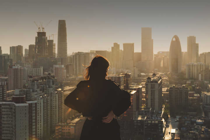Rear view of woman looking at city in sunlight