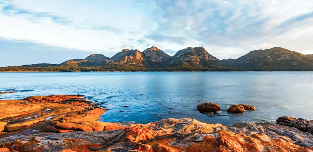 Küstenlandschaft mit Bergen und farbigen Felsen, Freycinet, Tasmanien, Australien.