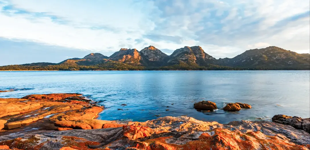 Küstenlandschaft mit Bergen und farbigen Felsen, Freycinet, Tasmanien, Australien.