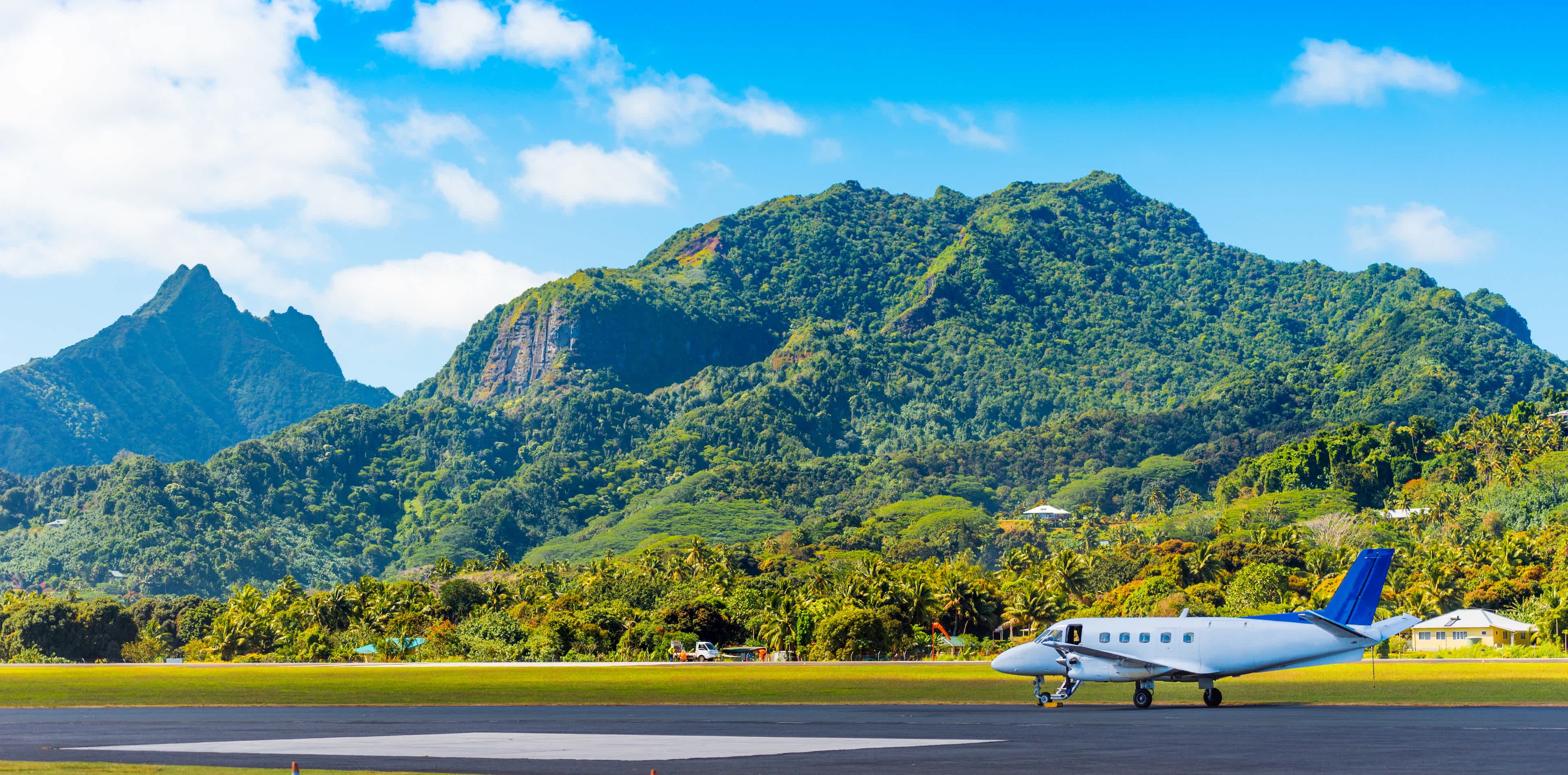 Das Flugzeug am Flughafen auf einem Hintergrund der Bergkulisse, Aitutaki Insel, Cook Islands. 