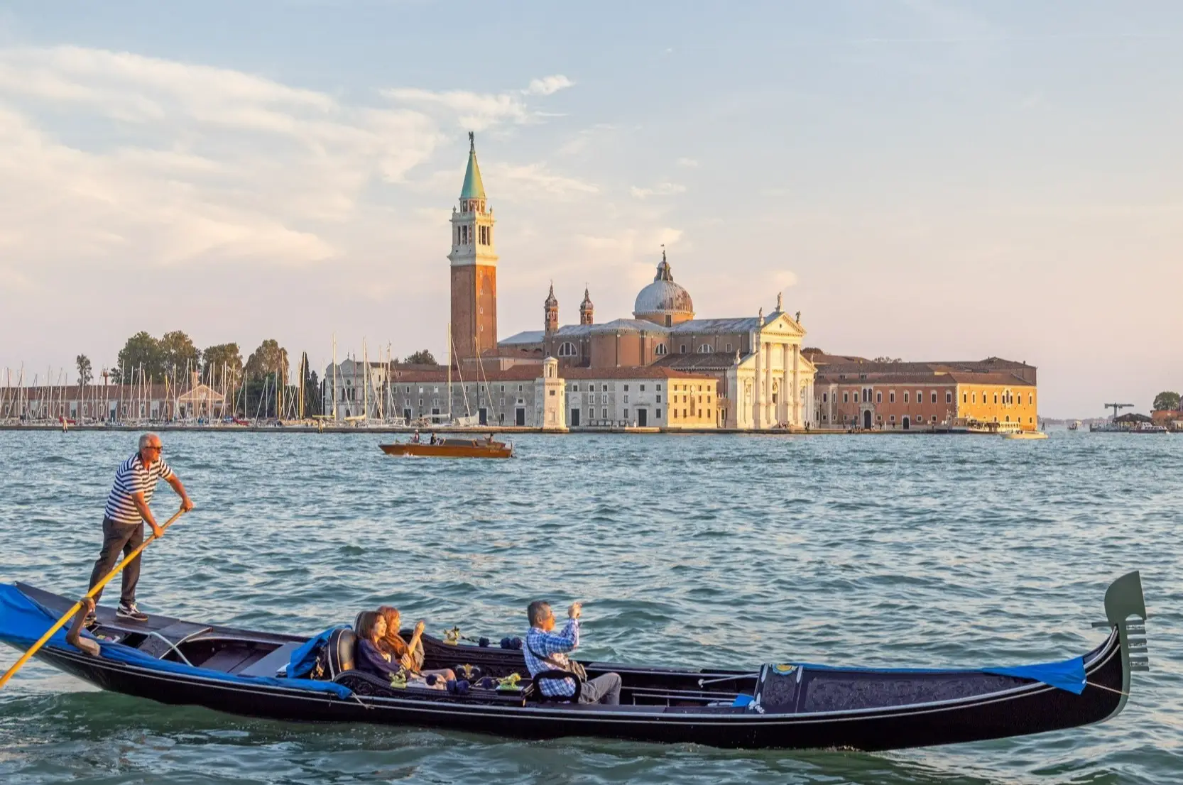 Une gondole avec trois touristes à Venise