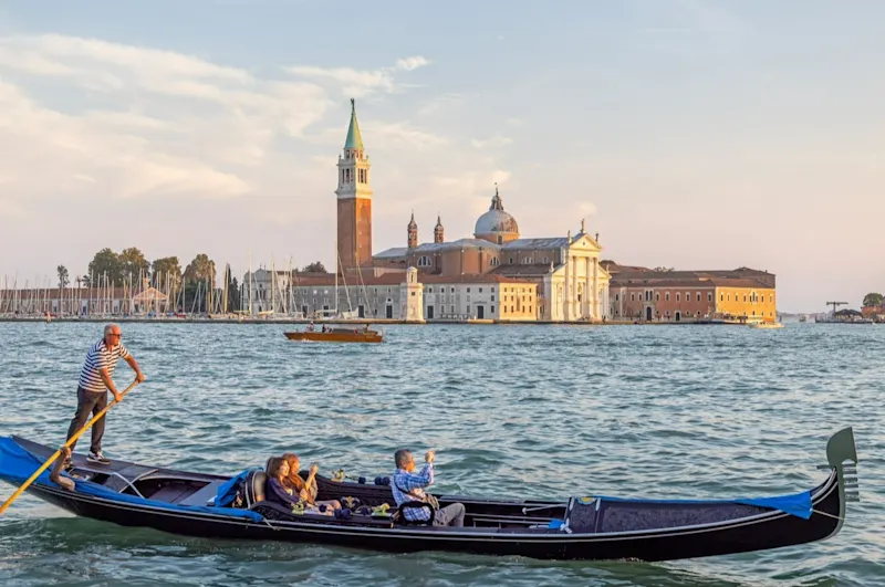 Une gondole avec trois touristes à Venise