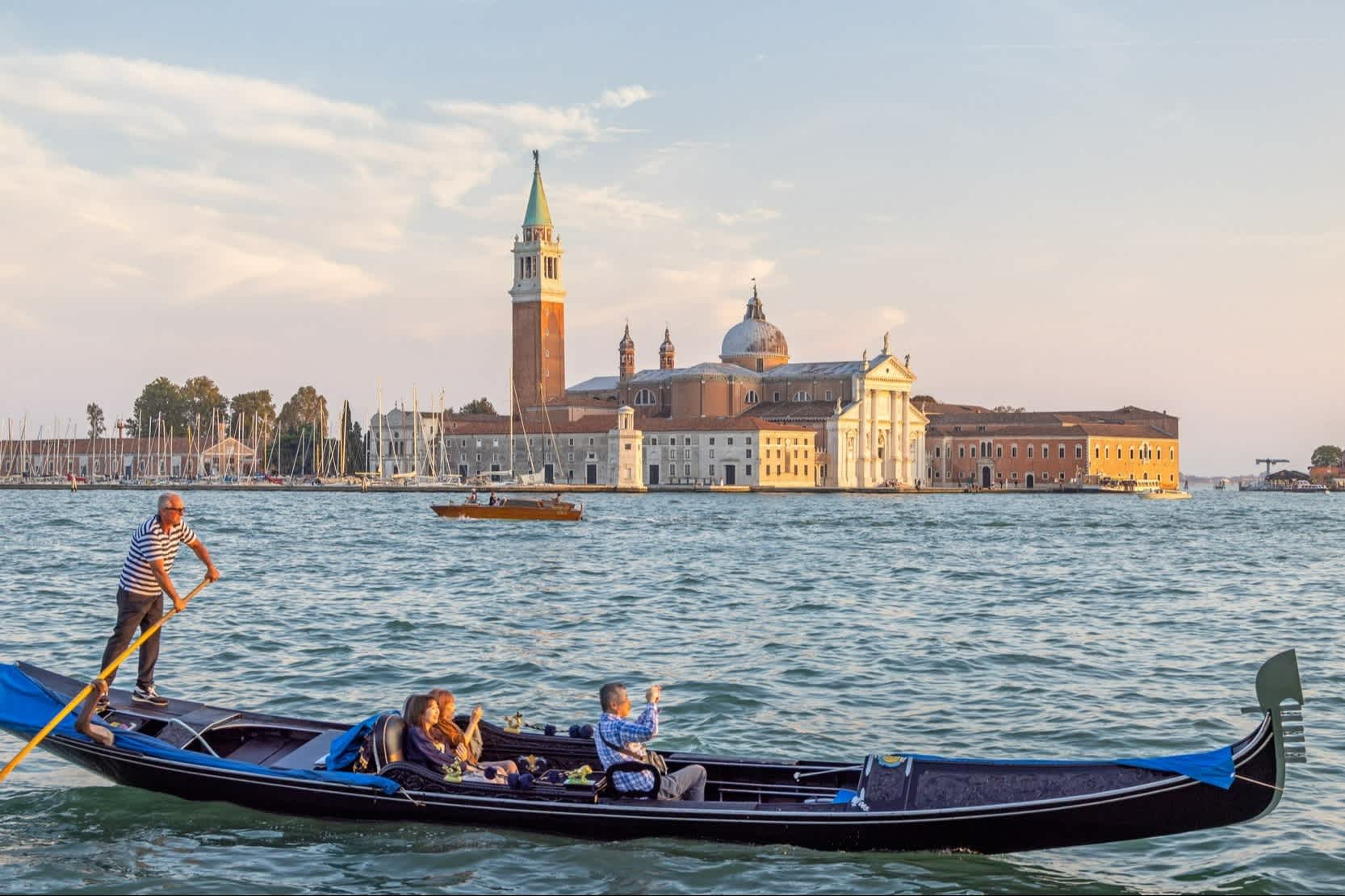 Eine Gondel mit drei Touristen in Venedig