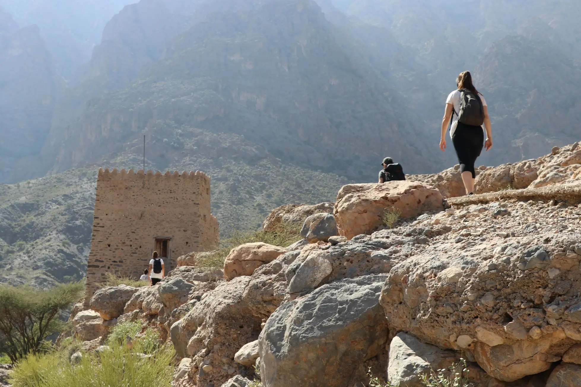 Trois personnes se promènent dans un paysage de montagne à Oman