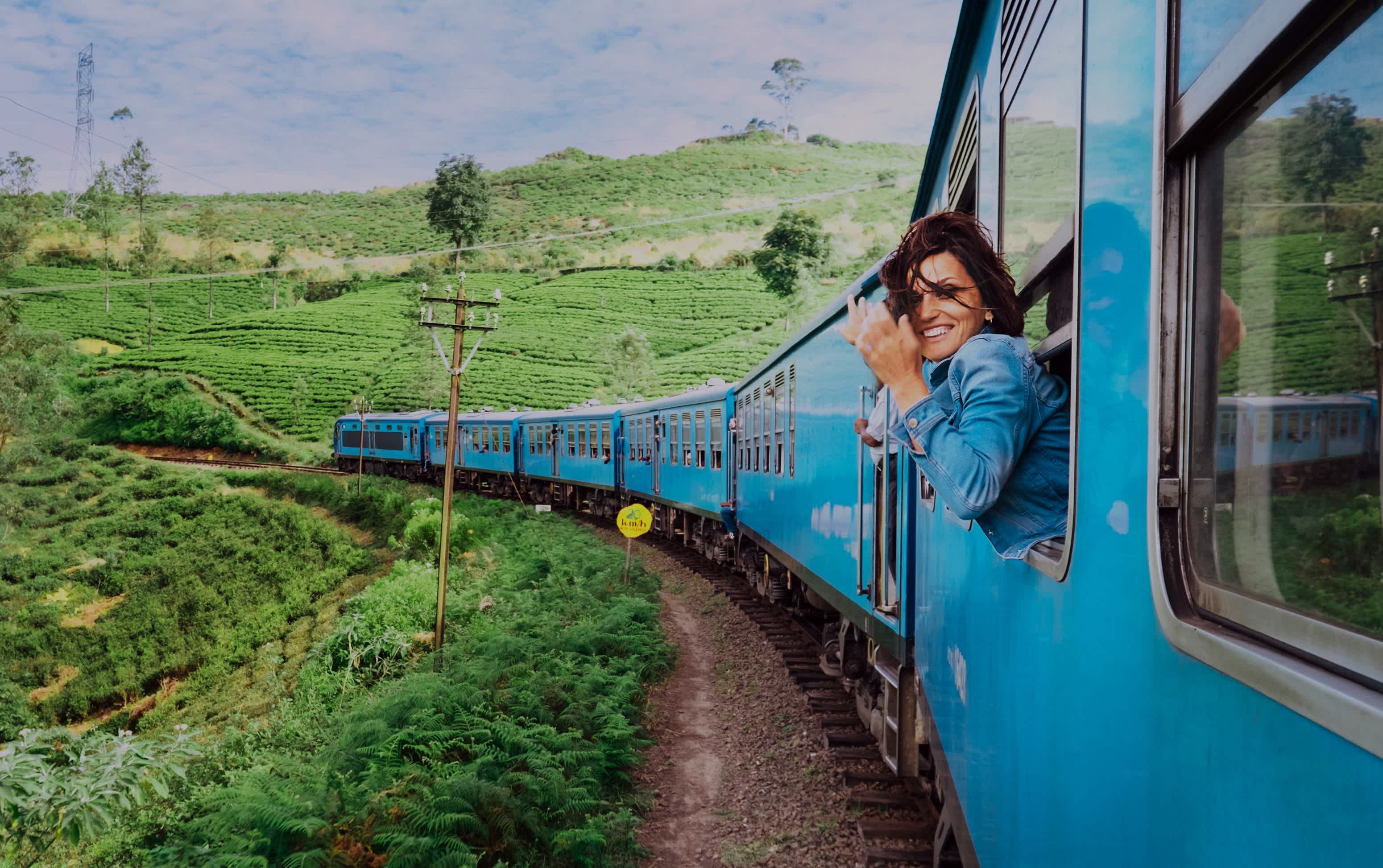 Lächelnde Frau schaut aus Fenster Reisen mit dem Zug unterwegs malerischsten Zug in Sri Lanka.