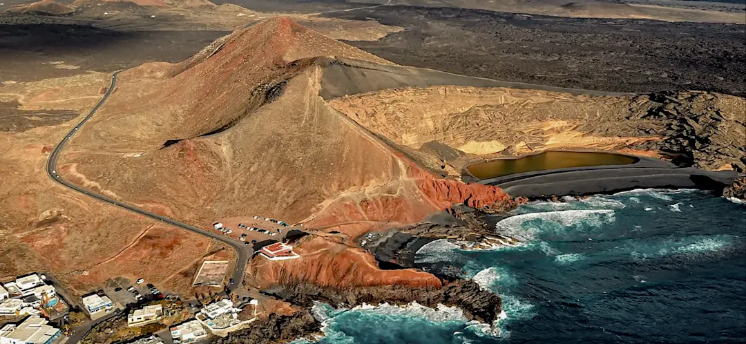 Vulkanlandschaft mit Krater, schwarzem Sand und Ozean. El Golfo, Lanzarote, Spanien.