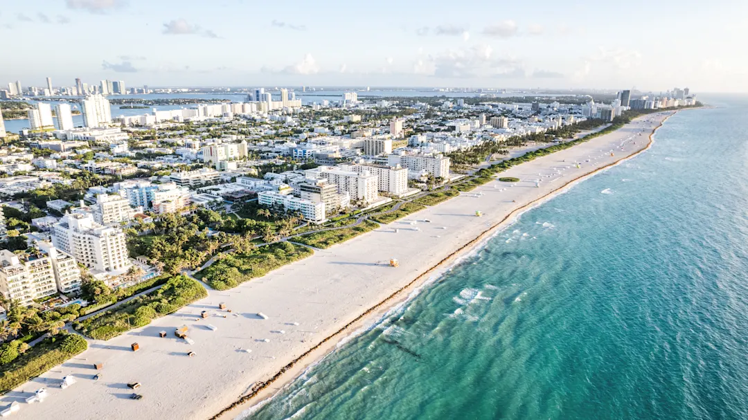 Luftaufnahme eines Strandes und von Gebäuden entlang der Küste. Miami, Florida, USA