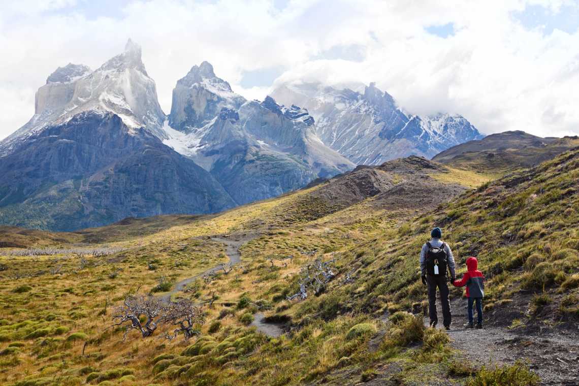 Vater und Sohn genießen eine herrliche Aussicht  in den Torres del Paine Nationalpark in Chile. 