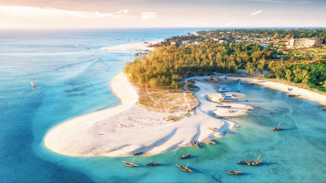 Luftaufnahme eines weißen Sandstrands mit türkisfarbenem Wasser, Sansibar, Tansania.