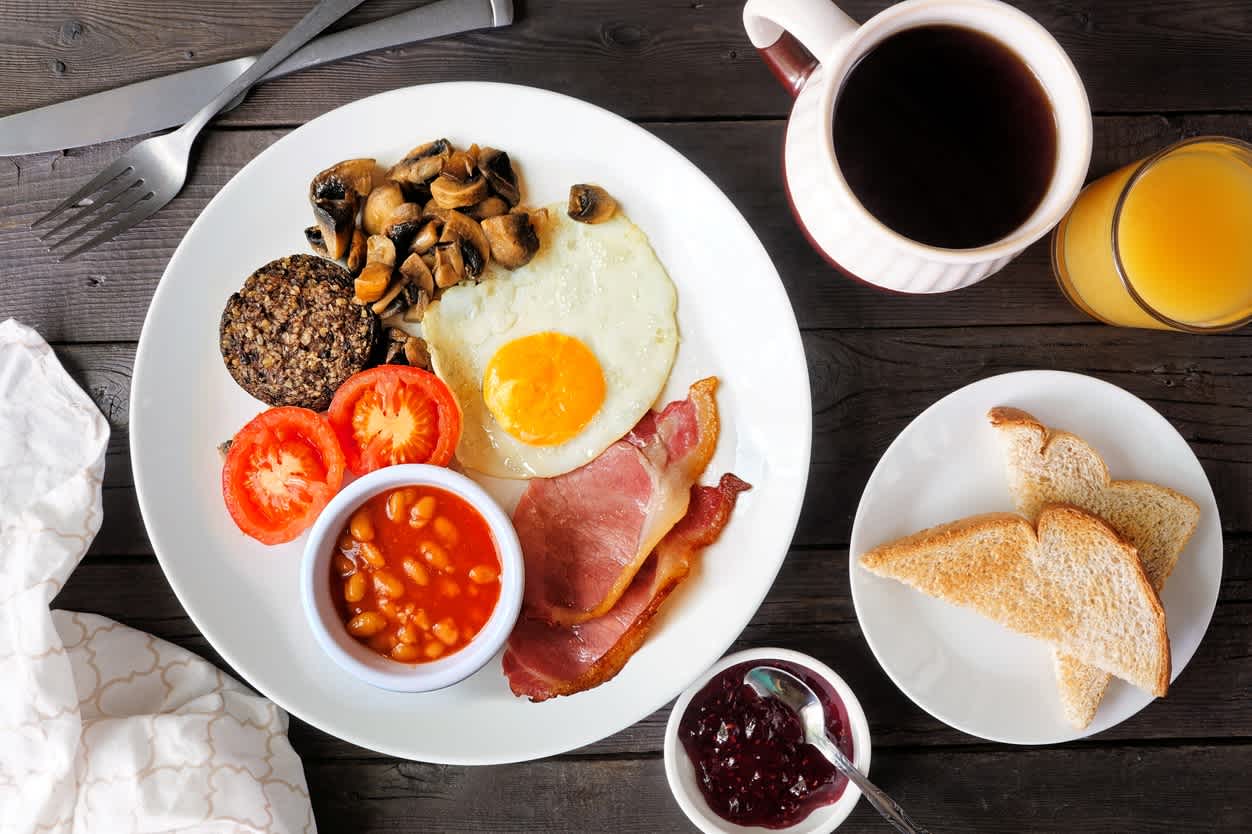 Komplettes schottisches Frühstück mit Haggis, Tischszene über dunklem Holz